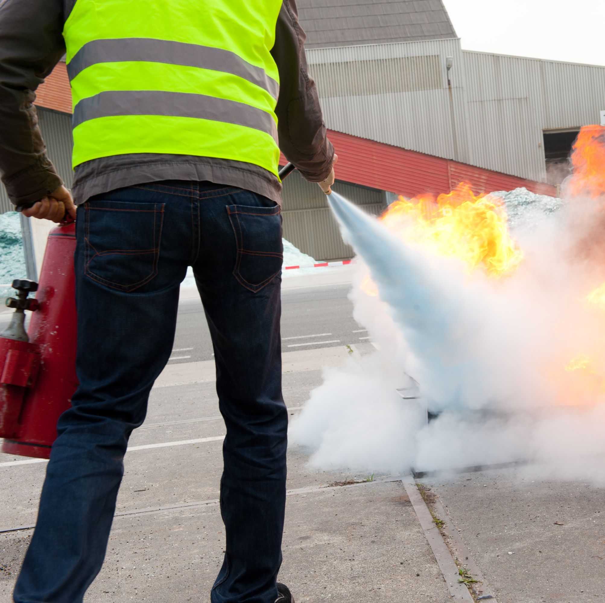 Brandschutztraining mit Feuerlöscher auf Industriegelände